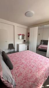 a bedroom with a large bed with a pink blanket at Nazario Sauro Cernobbio vacation home in Cernobbio