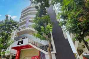 a tall white building with a yellow door at Super Collection O Manikonda in Hyderabad