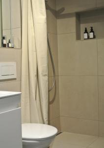 a bathroom with a shower curtain and a toilet at MI Apartment Ulm Design Studio by MAMO INTERIORS in Ulm