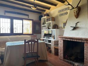 un soggiorno con camino, tavolo e sedia di Cortijo El Rincón a Cádiar