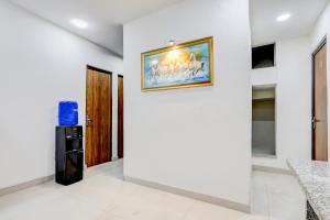 a room with a painting on the wall and a refrigerator at Super Hotel O Sector 25 Near Iskcon Temple Formerly Hotel Amazing House in New Delhi +33 photos