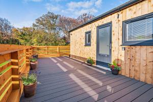 a wooden deck with a building with a door at The Caddy Shack in St. Andrews