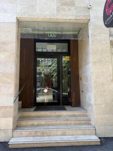 an entrance to a building with a woman walking through the door at Heights Accommodation Old Center in Bucharest +3 photos