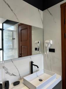 a bathroom with a sink and a mirror at Hotel Kvirila in Tsinsopʼeli