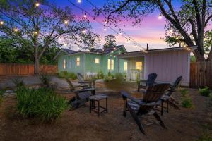 a backyard with chairs and a table and a house at The Grove-A: Cozy Cottage 2-Blocks to Marktplatz! in Fredericksburg