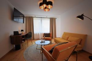 a living room with a couch and a table at Landgasthof zur Leonie - Wirtshaus & Boutiquehotel 