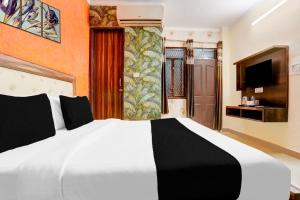 a bedroom with a large white bed and a television at Super Hotel O Uttam Nagar Near Akash Hospital in New Delhi