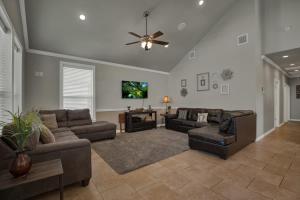a living room with couches and a ceiling fan at Let's Go Tubing! Awesome House-Next to River! in Third Crossing