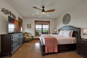 a bedroom with a bed and a ceiling fan at West End Lodge Resort Style Pool! in Fredericksburg