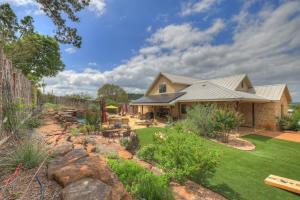 a backyard with a stone fence and a house at West End Lodge Resort Style Pool! in Fredericksburg
