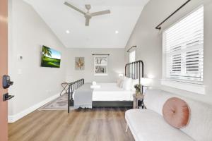 a white living room with a couch and a bed at The Grove B Stylish Cottage - Walk to Main in Fredericksburg