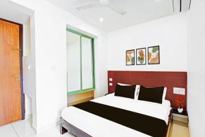 a bedroom with a large bed in a room at Super Hotel O Kaveri Road Mysore Formerly Hotel Nisarga in Mysore