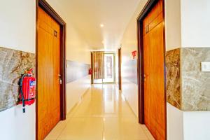 a hallway with a fire extinguisher in a building at Super Hotel O Kaveri Road Mysore Formerly Hotel Nisarga in Mysore