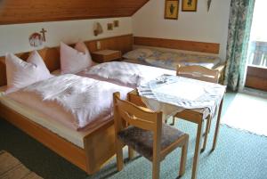 1 dormitorio con 1 cama, mesa y sillas en Treindlhof, en Fuschl am See