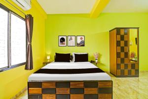 a bedroom with a large bed in a yellow room at Super Hotel O Kabardanga More Kolkata Formerly Royal Crown Banquet in Taliganja