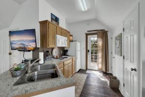 une cuisine avec un évier et un réfrigérateur dans l'établissement Cactus Flower Peaceful Hill Country Escape!, à Luckenbach 24 autres photos