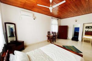 a bedroom with a bed and a ceiling fan at Tree Breeze in Negombo