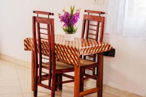 a table with two chairs and a vase of flowers at Tree Breeze in Negombo