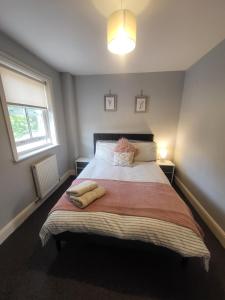a bedroom with a large bed with two towels on it at The Olive Cottages Axminster in Axminster