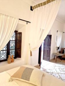 une chambre avec des rideaux blancs et un lit dans une pièce dans l'établissement Riad Dar El Mahja, à Marrakech 69 autres photos
