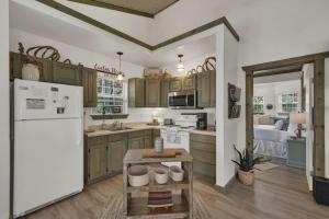 une cuisine avec des armoires vertes et un réfrigérateur blanc dans l'établissement Cactus Flower Peaceful Hill Country Escape!, à Luckenbach