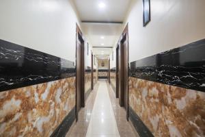 a hallway with black and brown marble walls at Collection O Tikonia Formerly Hotel Jatin in Haldwāni