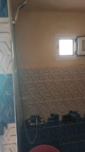 a bathroom with a shower and a window at Home family in Merzouga