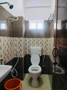 a bathroom with a toilet and a sink and a shower at venkateshwara ladies pg in Bengaluru