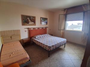 a small bedroom with a bed and a window at Casa vacanze ester in San Foca