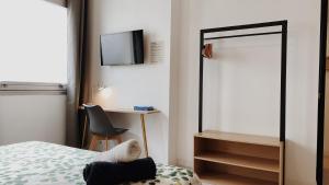 een slaapkamer met een bed, een bureau en een televisie bij La maison d'Angelique - Coliving Hotel - Gare de Niort in Niort