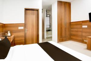 a bedroom with a bed and a desk and a television at Hotel O Cyber City Phase 3 in Gurgaon