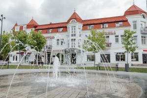 a fountain in front of a large building at Pysanka Hotel in Kolomiya