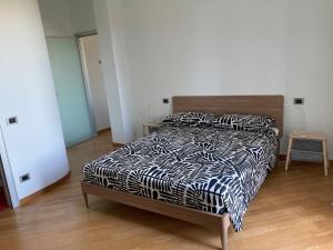 a bedroom with a bed with a black and white comforter at Luminoso appartamento panoramico in Cassano dʼAdda