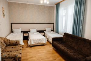 a living room with two beds and a couch at Pysanka Hotel in Kolomiya