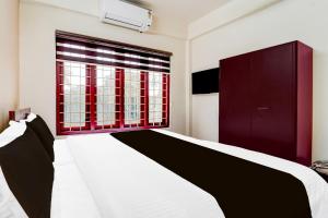a bedroom with a bed and a window at Super Collection O Kottayam Formerly Sap Inn in Kottayam