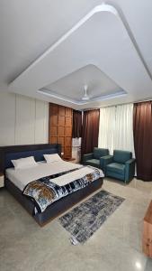 a bedroom with a bed and two blue chairs at Sri Rawatpura sarkar seva ashram in Haridwār