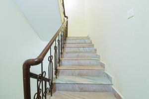 eine Treppe mit Holzstufen und Geländer in der Unterkunft Super Hotel O Dakshin Dwar Formerly Radha Krishna Niwas in Puri
