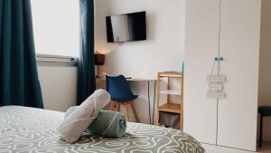 een slaapkamer met een bed en een tv aan de muur bij La maison d'Angelique - Coliving Hotel - Gare de Niort in Niort