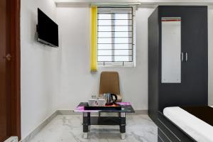a small room with a table and a bed and a tv at Super Collection O Mourigram Near Andul Road in Sānkrāil