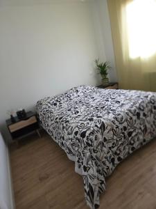 a bed in a bedroom with a black and white blanket at Chambre Cosy chez l'habitant - parking - spa -terrasse in Saint-Alban