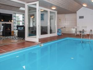 a large swimming pool with a tub and a bathroom at Luxury Pool Retreat in Ebeltoft - By Traum Ferienwohnungen in Ebeltoft