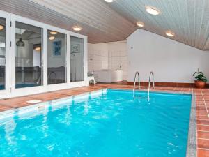 una piscina cubierta de agua azul en una casa en Luxury Pool Retreat in Ebeltoft - By Traum Ferienwohnungen, en Ebeltoft