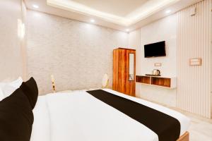 a bedroom with a bed and a tv on a wall at Super Townhouse Faridabad Railway Station Formerly Hotel Royals Paradaise in Faridabad +24 photos