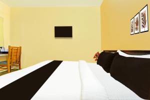 Un dormitorio con una cama y una mesa con una silla. en Super Collection O Kureepuzha Kollam, en Kollam 29 fotos más