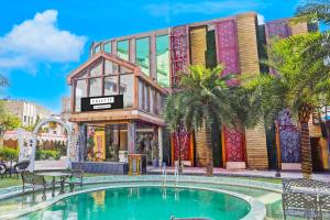 un edificio con piscina frente a un centro comercial en Palette by CheckIn Patliputra Colony Formerly The Aurum, en Patna