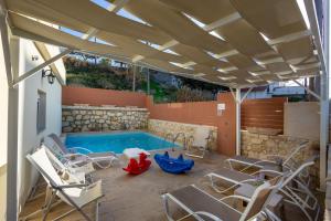a patio with chairs and a swimming pool at Thalassa Beachfront Villa with private pool in Skaleta