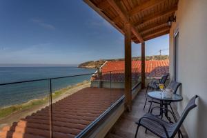 a balcony with a table and chairs and the ocean at Villa Thalassa in Skaleta