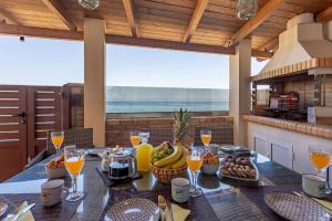 a table with a bunch of fruit and glasses of orange juice at Villa Thalassa in Skaleta
