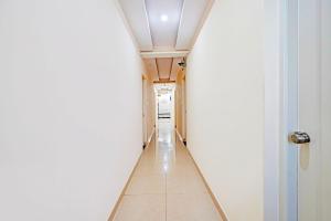 a hallway with a white wall and a white ceiling at Collection O Niladri Road in Kammasandra