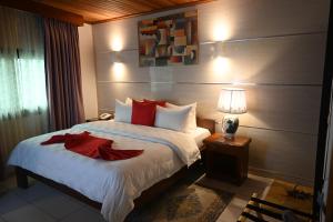 a bedroom with a large bed with red pillows at GRAND Hôtel Akwa in Douala